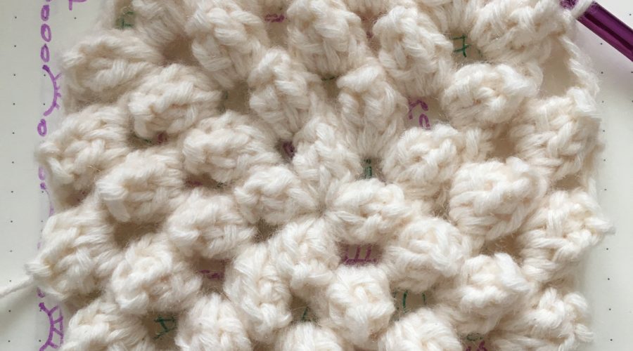 A crochet square of popcorn stitches.