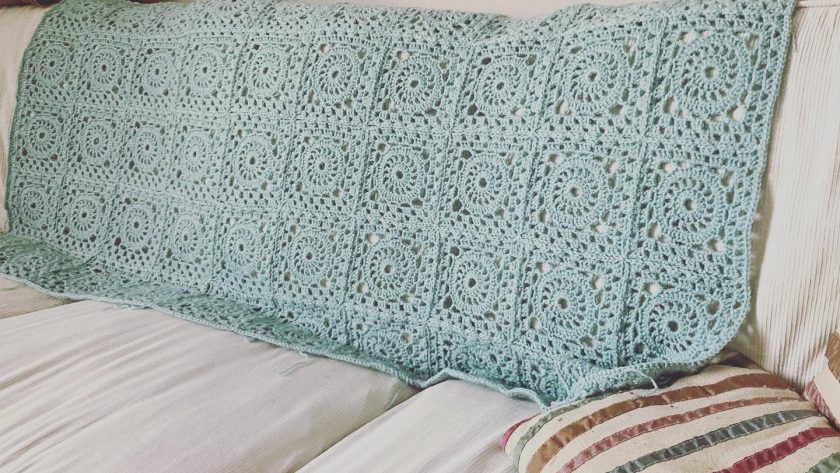 crochet blanket displayed on the back of a sofa.
